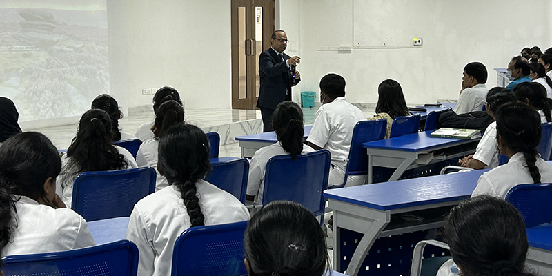 Dr. Joshi speaking to students sitting in the college hall
